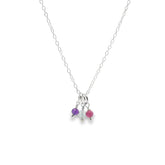 Necklace with three small colored beads on a white background