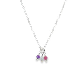 Necklace with three small colored beads on a white background
