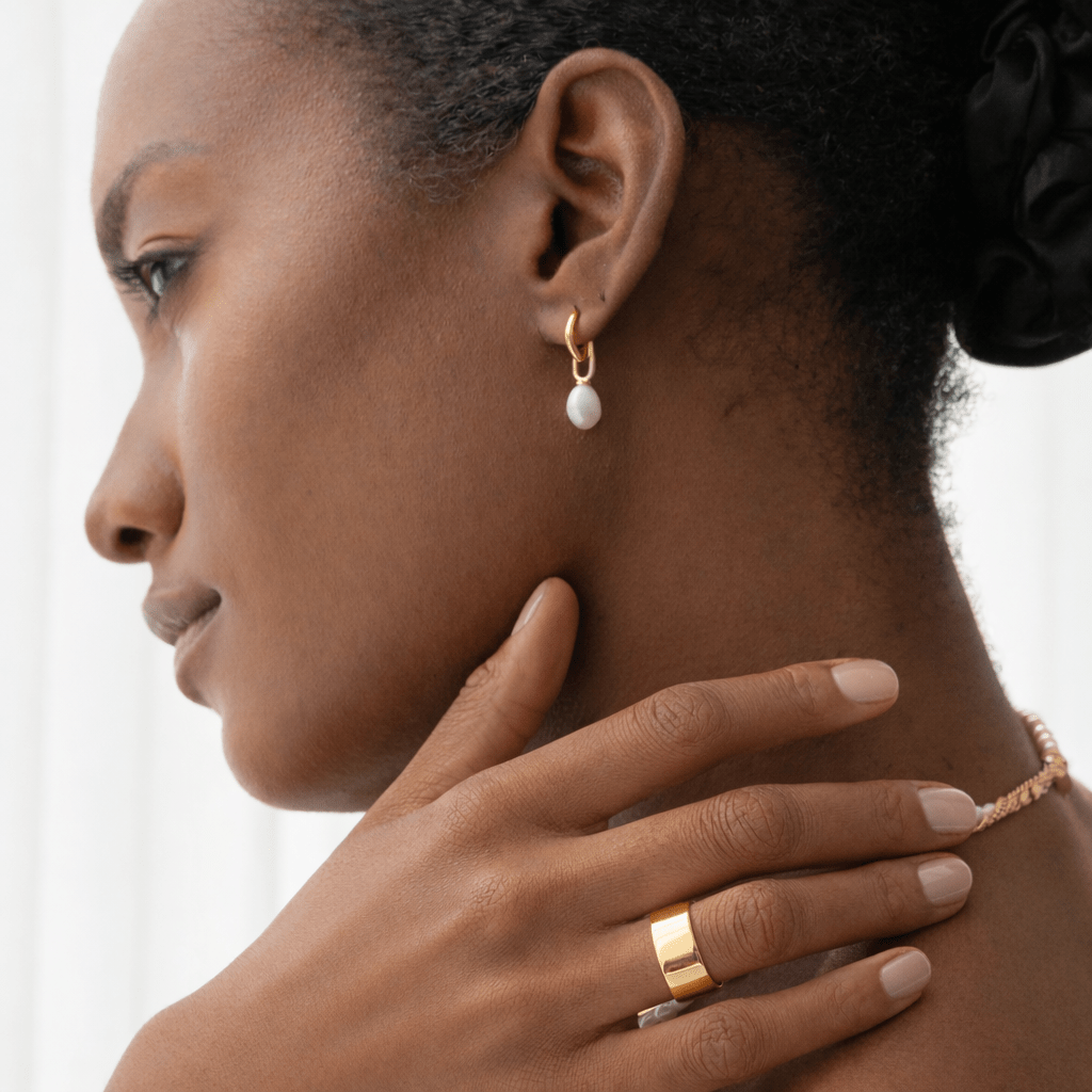 Woman wearing gold earrings and ring 
