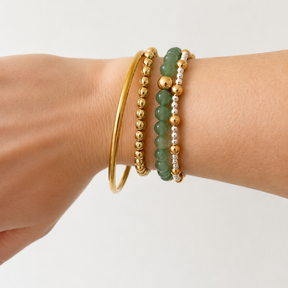 classic thin gold bangle stacked with ball bracelets